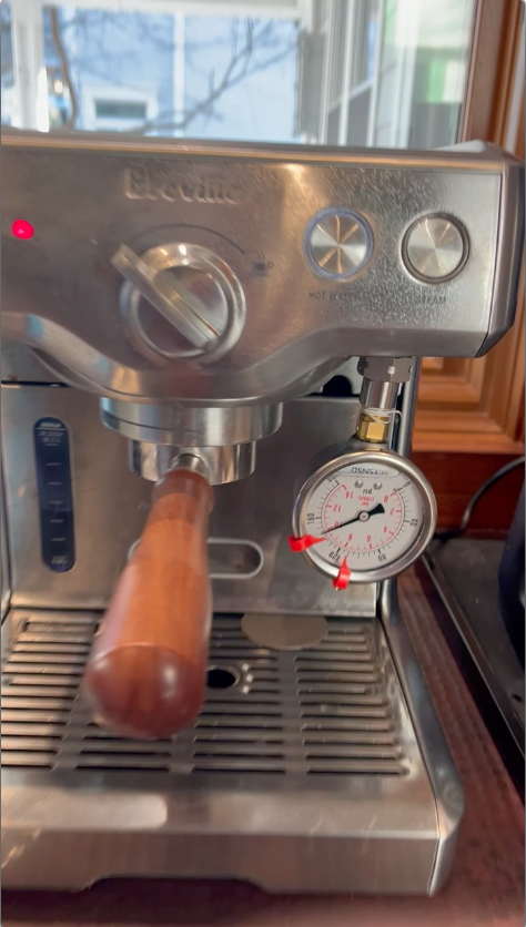 pressure gauge attached in place of the steam wand, machine set to Wand and Hot Water