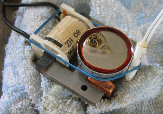 A digital thermometer probe held to the rotor by a rubber band